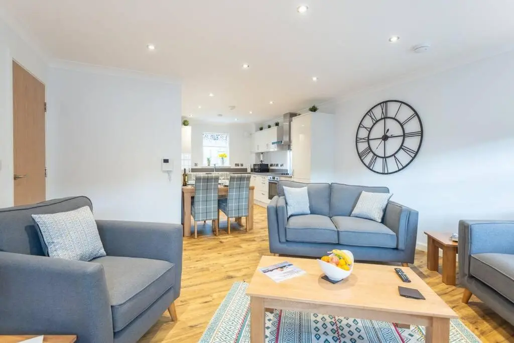 a living room with two blue couches and a table at Stylish & Modern Apartment in Inverness