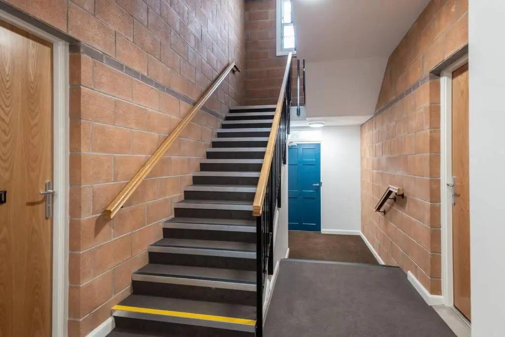 a staircase in a building with a brick wall at Stylish & Modern Apartment in Inverness