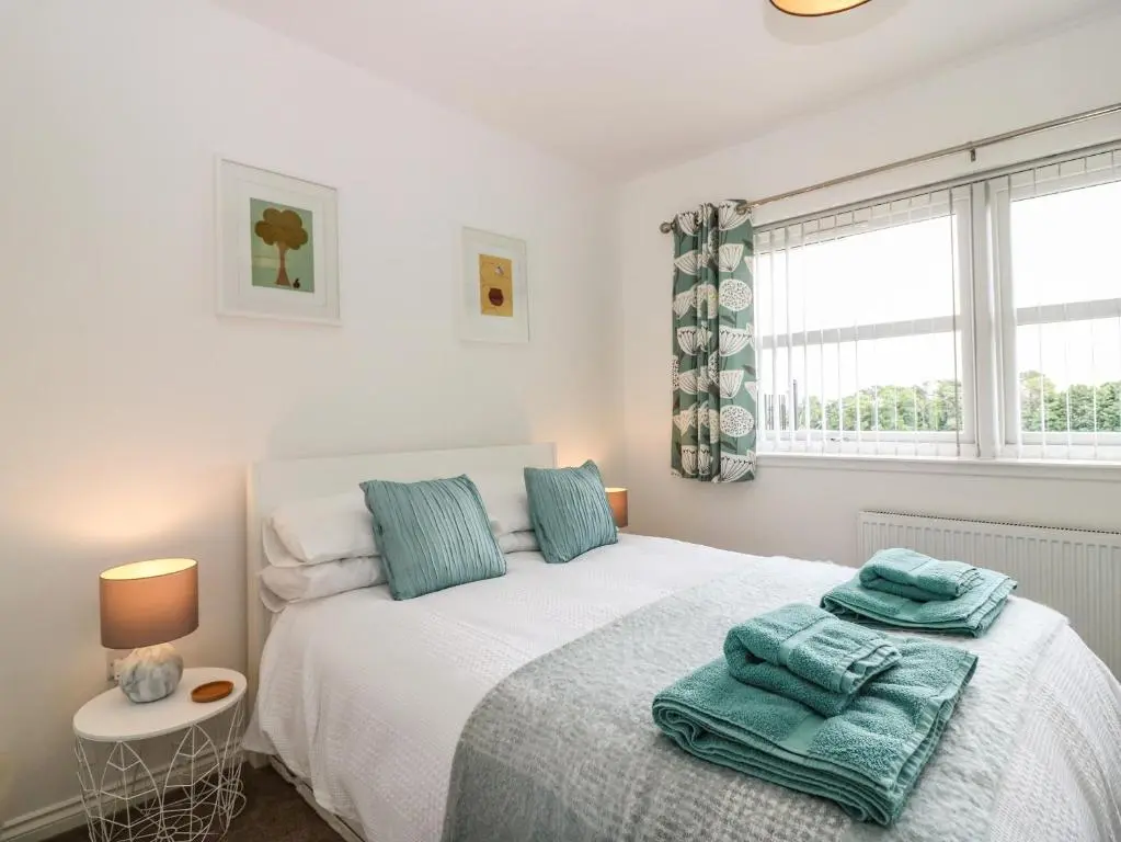 a bedroom with a bed with blue towels on it at 38 The Views in Elgin