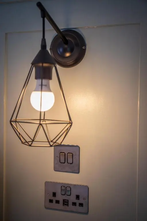 aendant light hanging from a wall with a lightswitch at Great Glen Way Canal Side Apartment in Inverness