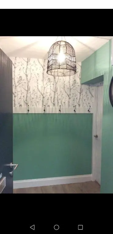 a room with a green wall and a chandelier at Great Glen Way Canal Side Apartment in Inverness