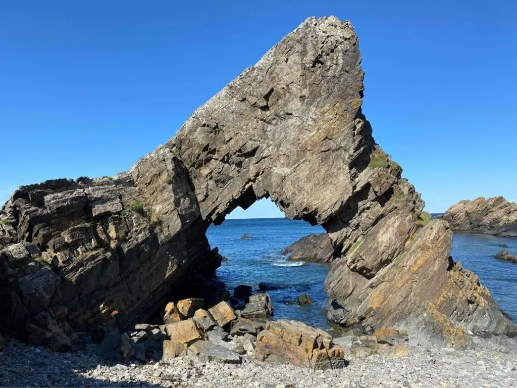 an arch in the rocks on the beach at Bellevue Holiday Cottage in Gardenstown