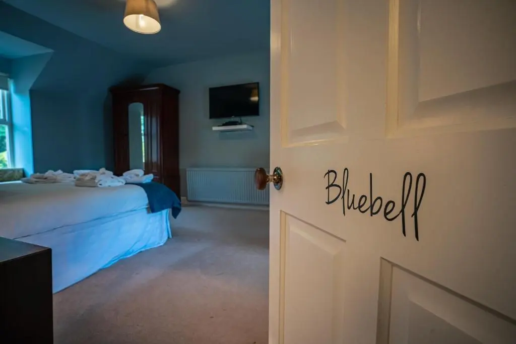 a bedroom with a bed and a door with the word blued at The Farmhouse, 6 bed property, Forres in Forres