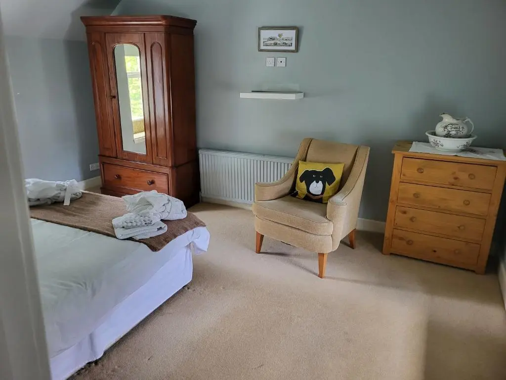 a bedroom with a bed and a chair and a dresser at The Farmhouse, 6 bed property, Forres in Forres