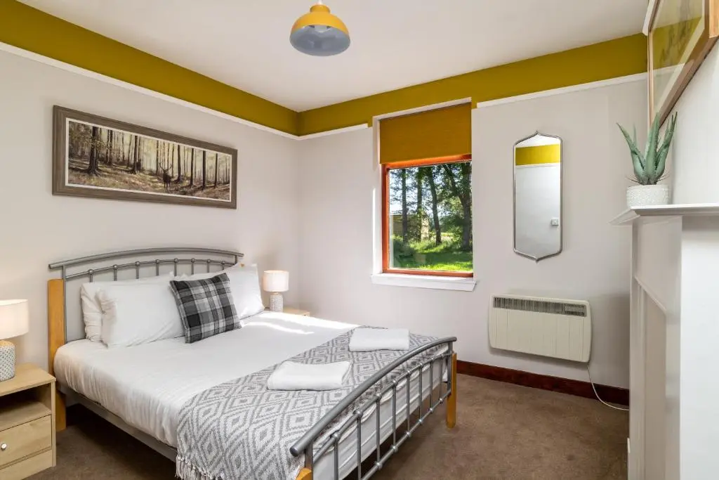 a bedroom with a bed and a window at Stunning, Remodelled Cottage, Picturesque Location in Duncanston