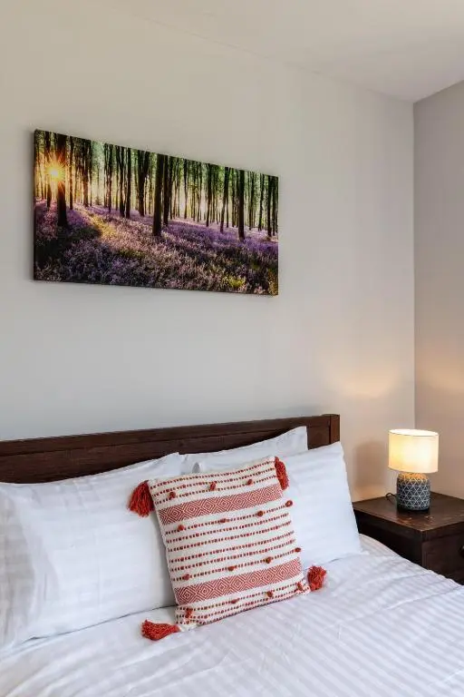 a bedroom with a bed with a painting on the wall at Stunning, Remodelled Cottage, Picturesque Location in Duncanston