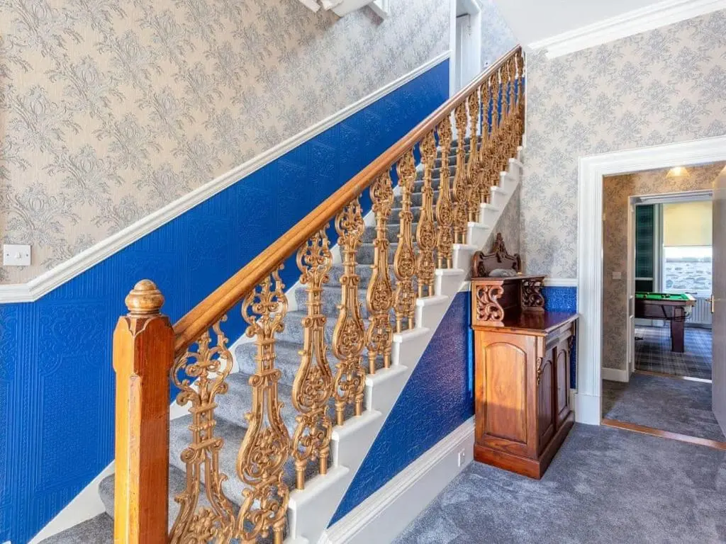 a staircase with blue walls and a blue and white wall at North Bank House in Lybster