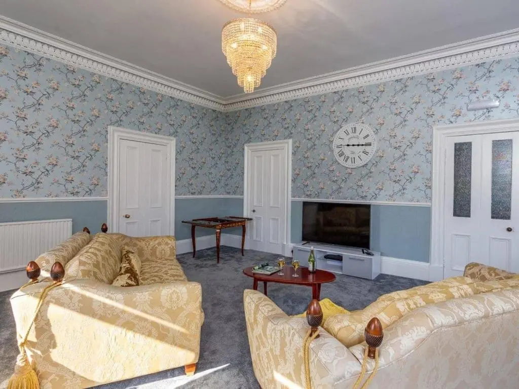 a living room with two couches and a clock on the wall at North Bank House in Lybster