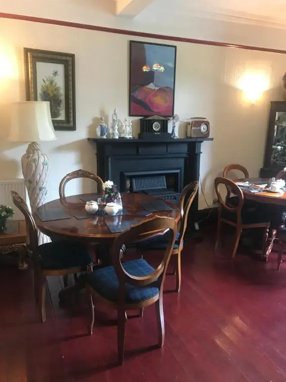 a dining room with a table and chairs and a fireplace at Cavell House in Inverness