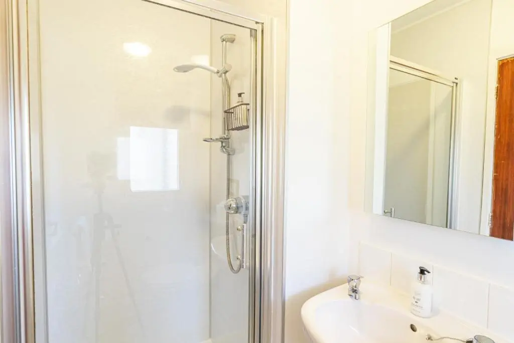 a bathroom with a shower and a sink at Fern Lodge 2 with Hot Tub in Belladrum