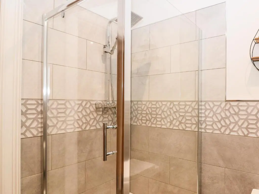 a shower with a glass door in a bathroom at The Clock Tower at The Institute Executive Apartments in Keith