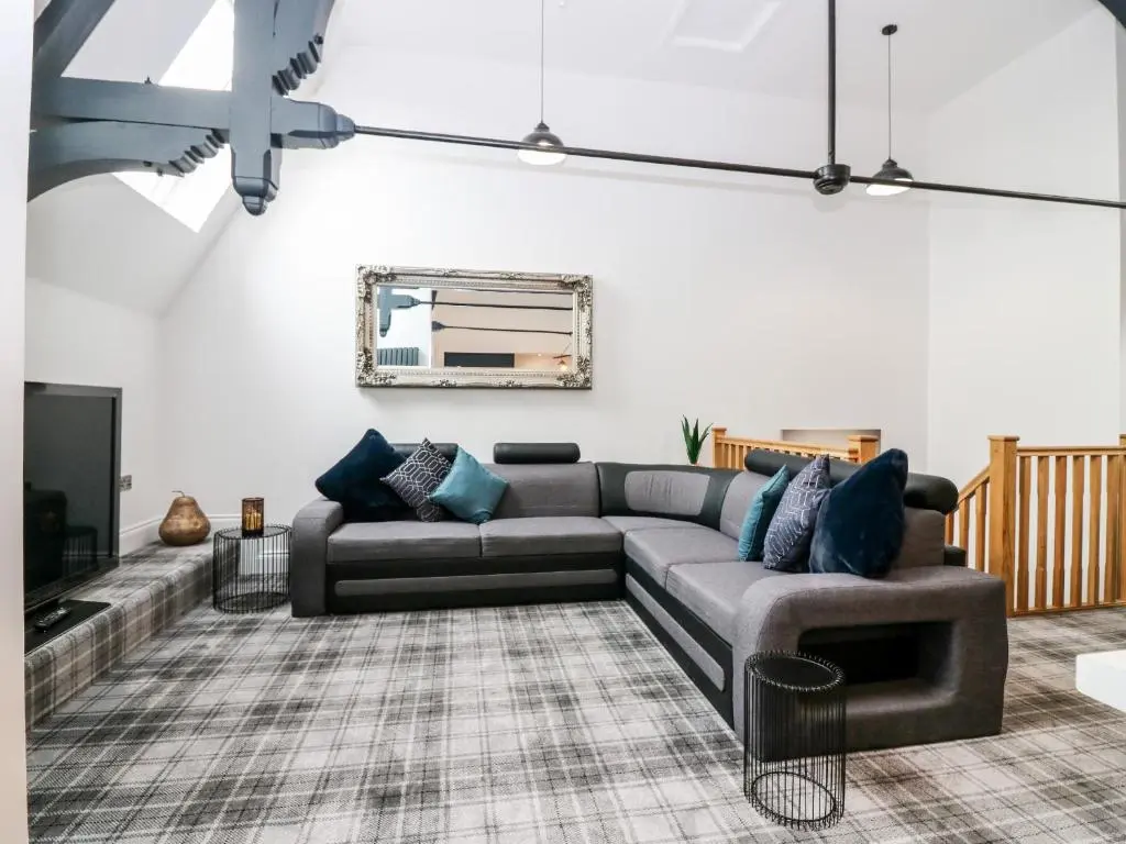 a living room with a couch and a tv at The Clock Tower at The Institute Executive Apartments in Keith