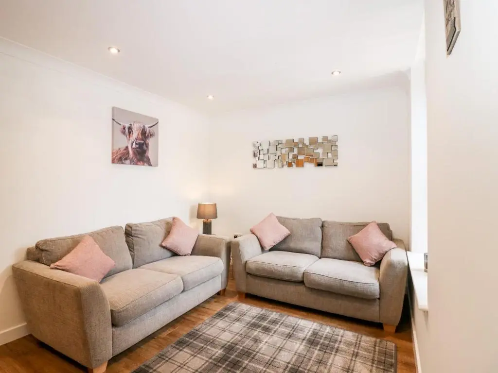 a living room with two couches and a rug at The Keepers Cottage at The Institute Executive Apartments in Keith