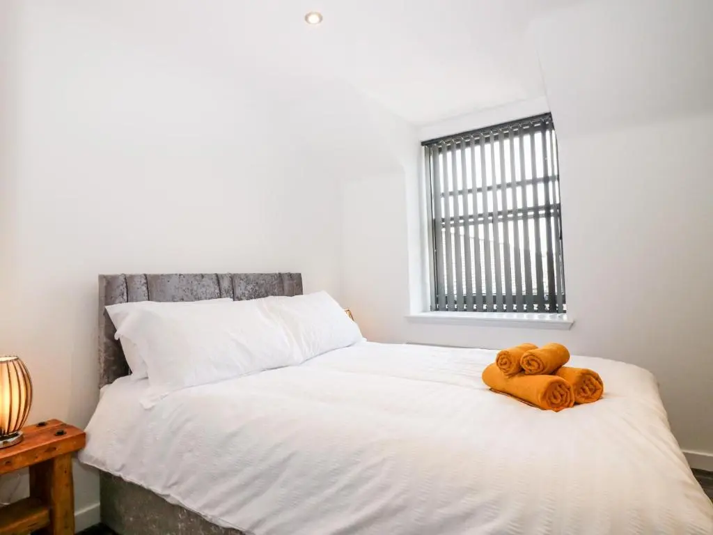a bedroom with a bed with two towels on it at The Keepers Cottage at The Institute Executive Apartments in Keith