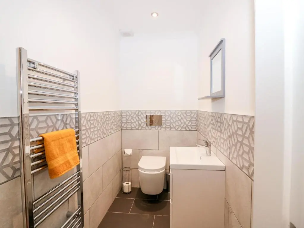 a small bathroom with a toilet and a sink at The Keepers Cottage at The Institute Executive Apartments in Keith