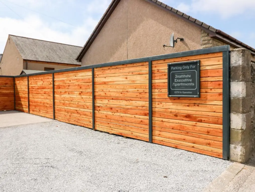 a wooden garage door with a sign on it at The Keepers Cottage at The Institute Executive Apartments in Keith