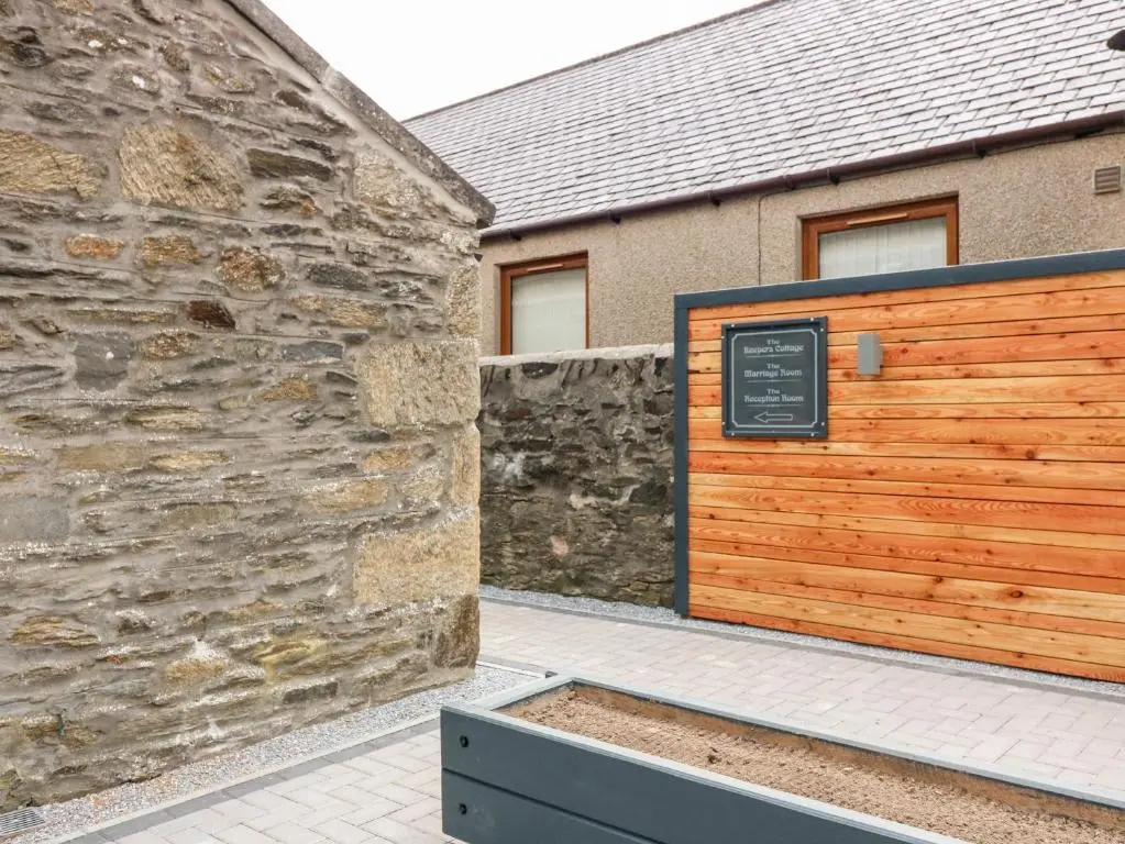 a building with a wooden gate and a stone wall at The Court Room at The Institute Executive Apartments in Keith