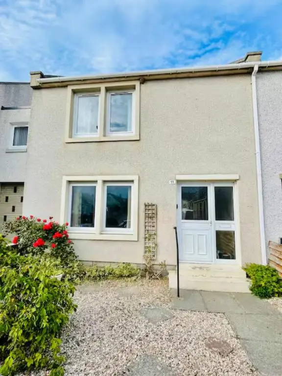 a brick house with white doors and red flowers at Spacious 2 Bedroom Home in Picturesque Cullen in Cullen