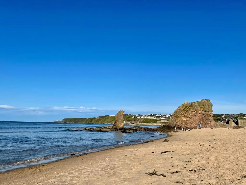 a beach with some rocks in the water at Spacious 2 Bedroom Home in Picturesque Cullen in Cullen