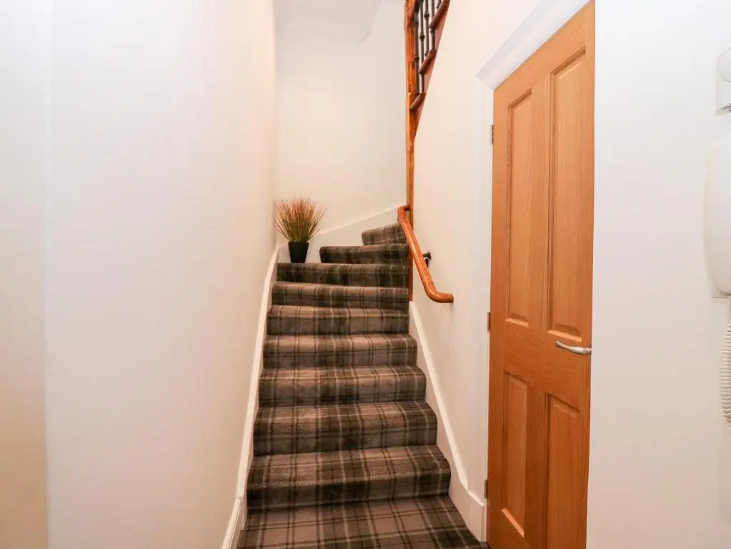a stairway with a plaid carpet and a wooden door at Council Chambers at The Institute Executive Apartments in Keith