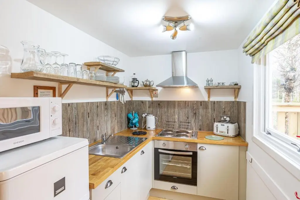 a kitchen with a sink and a microwave at Bracken Lodge 5 with Hot Tub in Belladrum