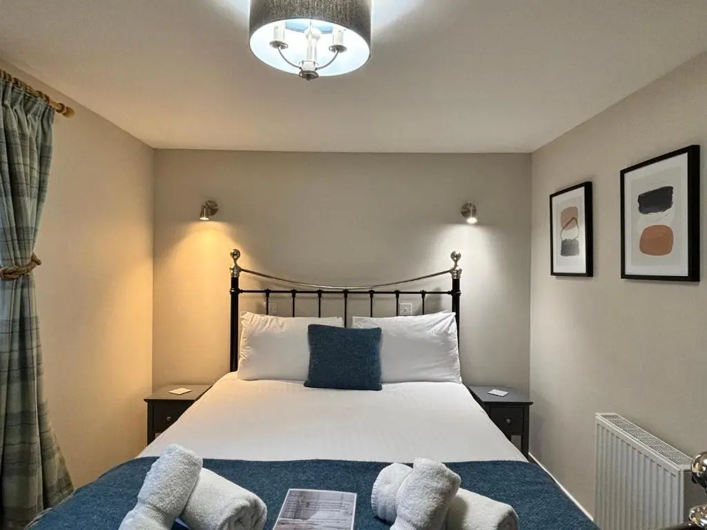 a bedroom with a bed with two towels on it at Bracken Lodge 6 with Hot Tub in Belladrum