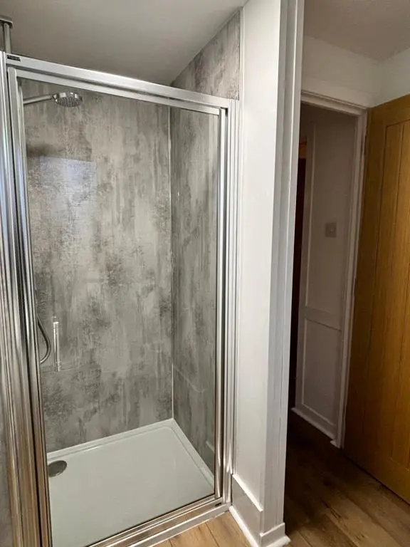 a shower with a glass door in a bathroom at Bracken Lodge 6 with Hot Tub in Belladrum