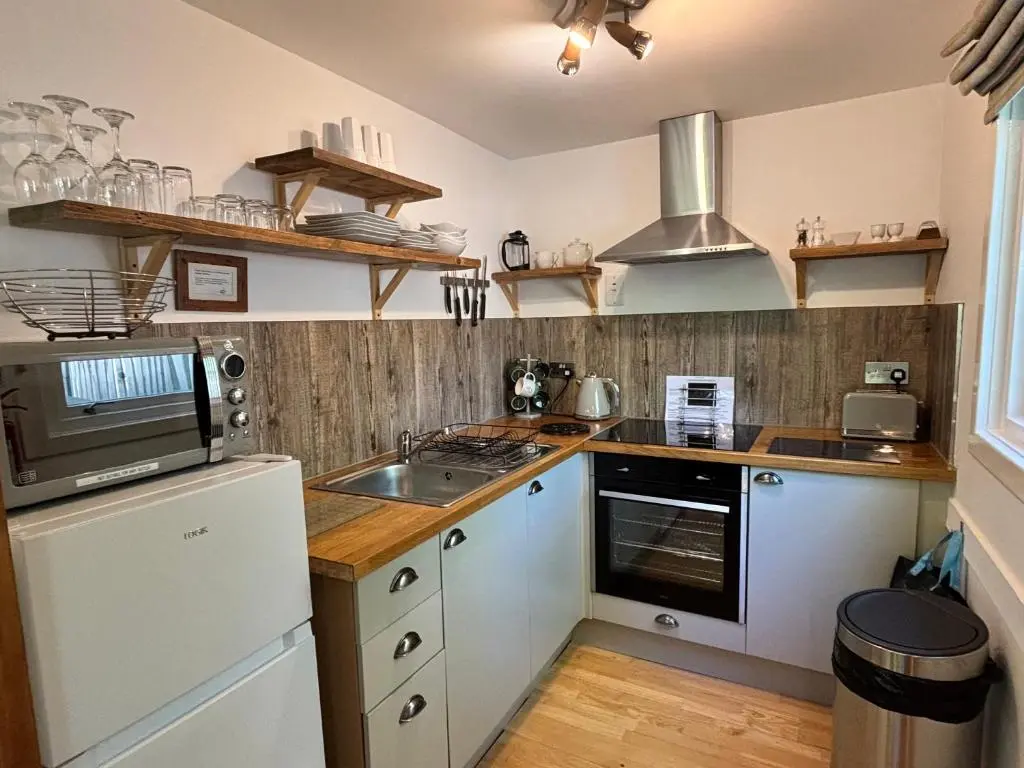 a kitchen with a sink and a stove top oven at Bracken Lodge 7 with Hot Tub in Belladrum
