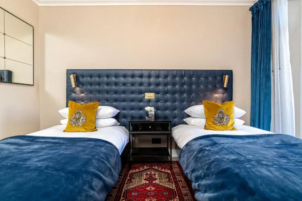 two beds sitting next to each other in a room at Pamper yourself in our DOUBLE SIZED copper tub -2 bedroom villa in Inverness