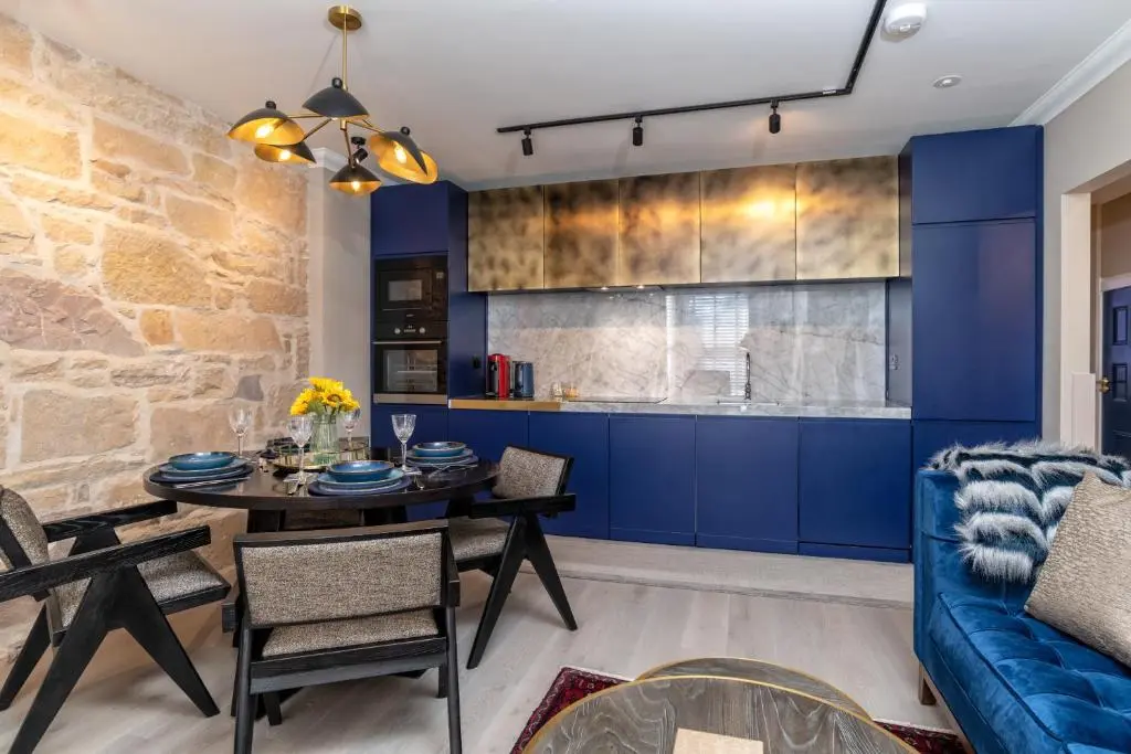a kitchen and dining room with blue cabinets and a table at Pamper yourself in our DOUBLE SIZED copper tub -2 bedroom villa in Inverness