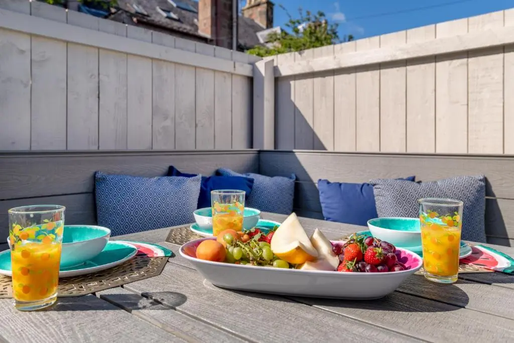 a table with a bowl of fruit and a bowl of juice at Pamper yourself in our DOUBLE SIZED copper tub -2 bedroom villa in Inverness