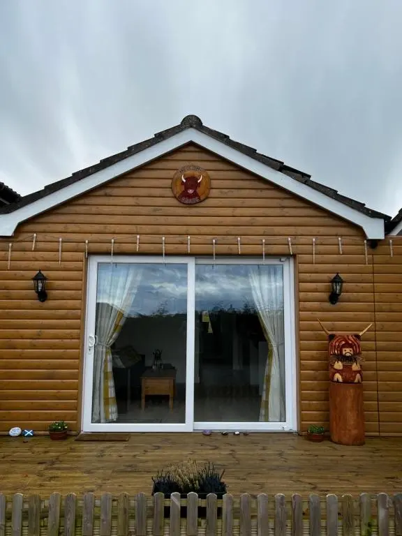 a house with a large window on the side of it at TomaX Garden Cabin Free Parking in Inverness