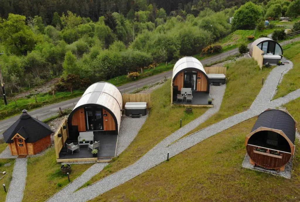 a group of modular homes on a grassy hill at Highland Premier Glamping Pods in Beauly