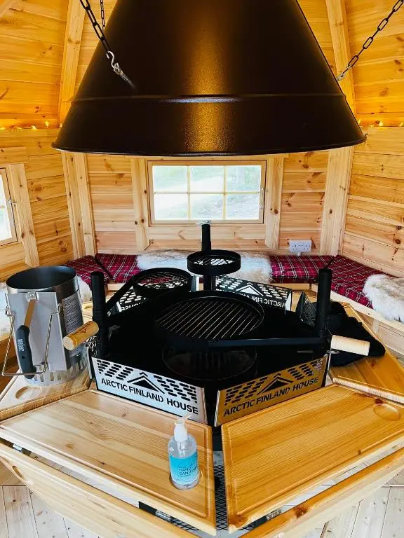 a stove in a cabin with boxes on a table at Highland Premier Glamping Pods in Beauly