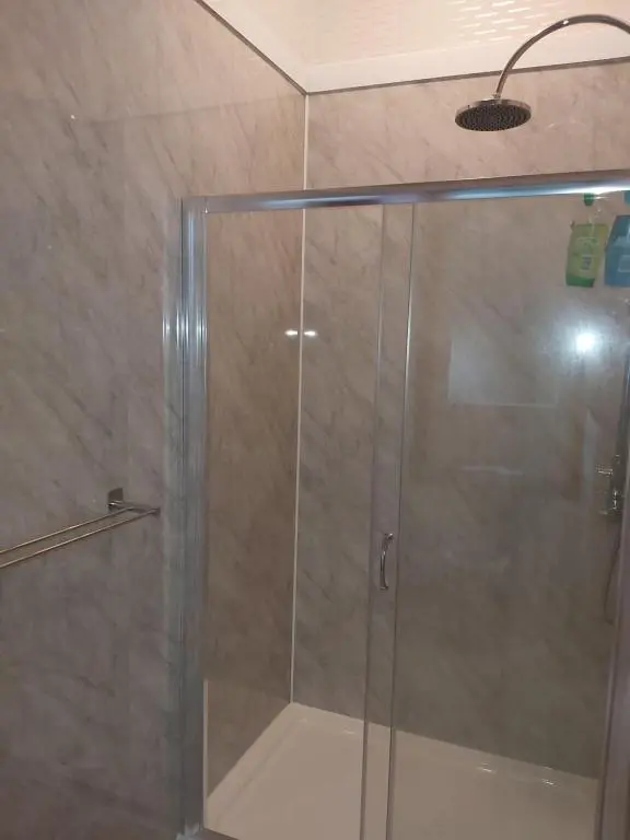 a shower with a glass door in a bathroom at Kirkhouse in Wick