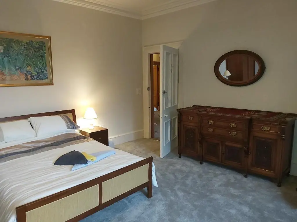 a bedroom with a bed and a dresser and a mirror at Kirkhouse in Wick