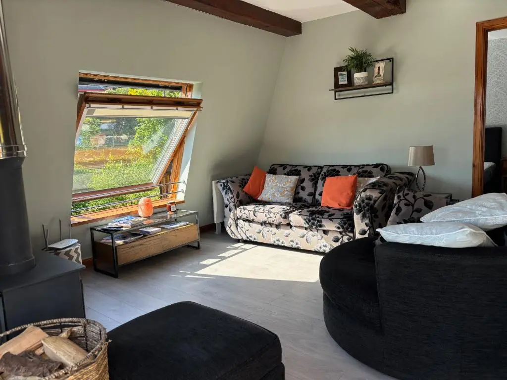 a living room with a couch and a window at Cosy coastal hideaway with incredible sea views in Fortrose
