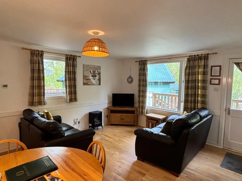 a living room with two couches and a table at Bracken Lodge 8 with Hot Tub in Belladrum