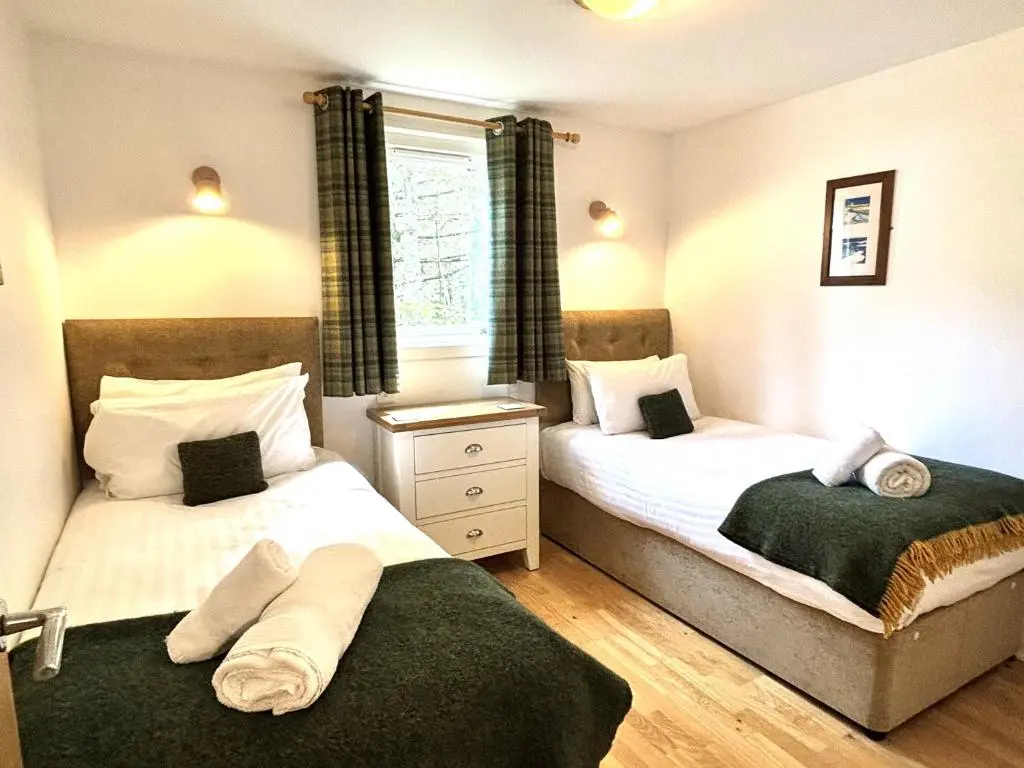 a bedroom with two beds and a window at Bracken Lodge 8 with Hot Tub in Belladrum