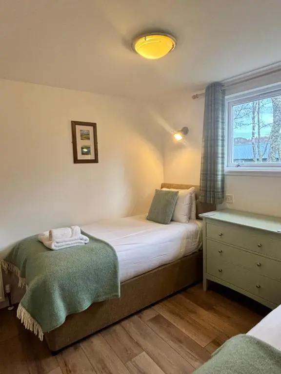 a bedroom with two beds and a window at Bracken Lodge 16 with Hot Tub in Belladrum