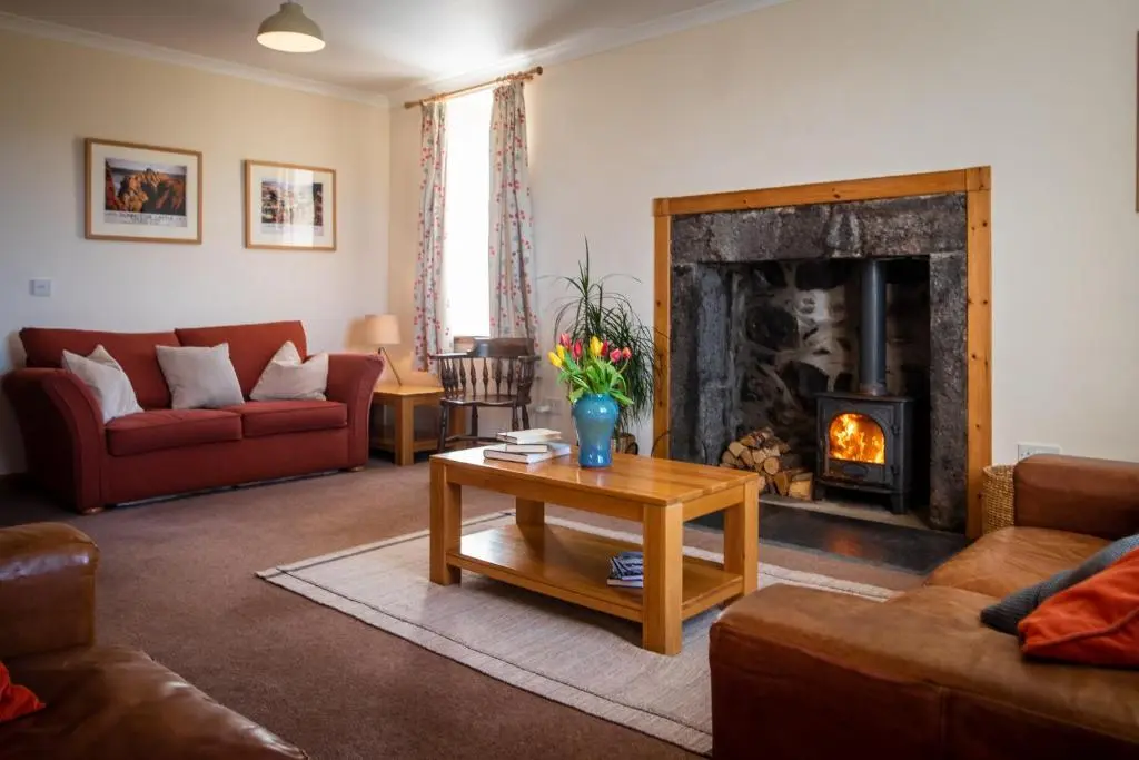 a living room with couches and a fireplace at Hillside Cottage in Aberdeen