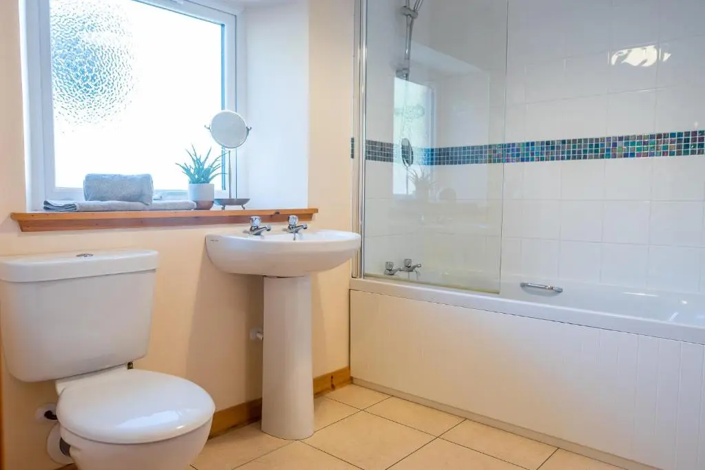 a bathroom with a toilet and a sink and a shower at Hillside Cottage in Aberdeen