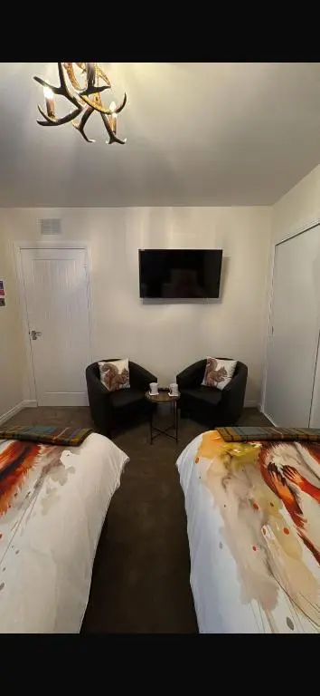 a living room with two beds and a couch at Haste Ye Back in Inverness