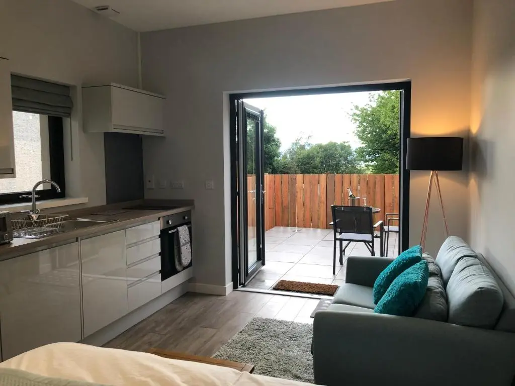 a living room with a couch and a kitchen at Fyrish View in Dingwall