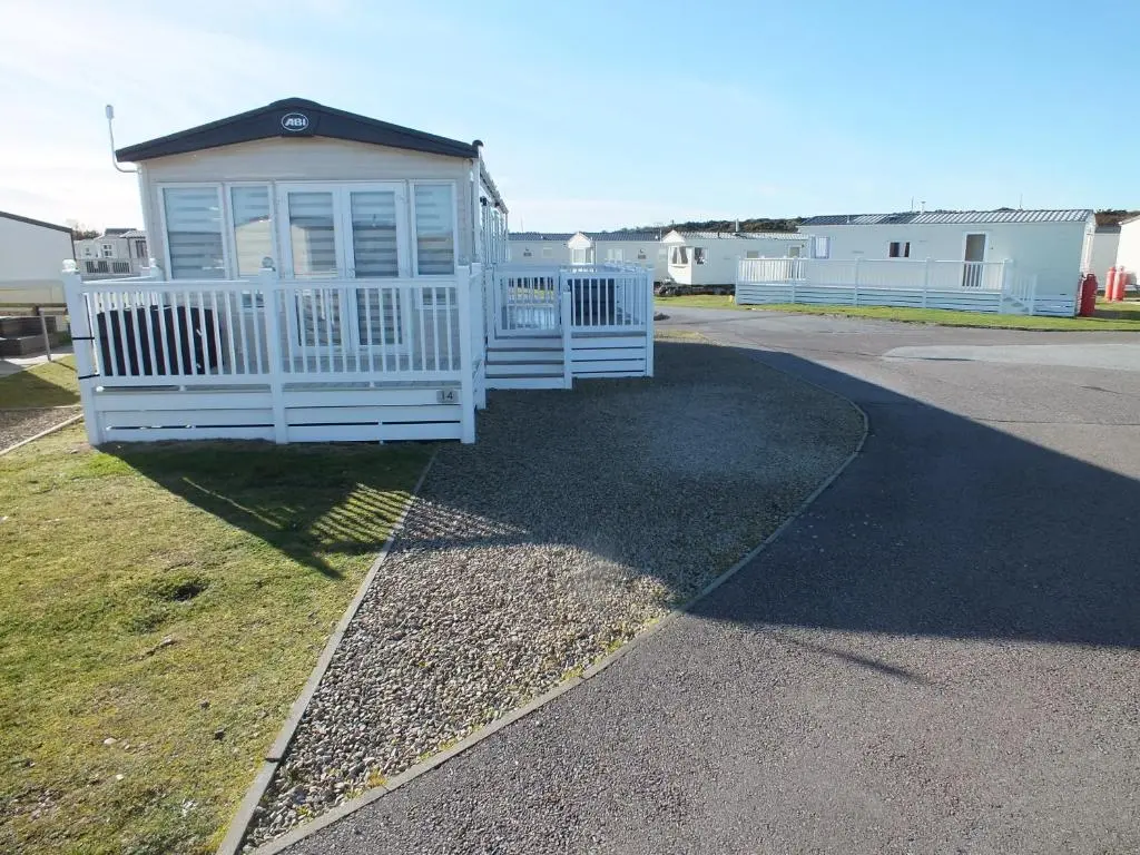 a small white house on the side of a road at Beachside Lighthouse 14 in Lossiemouth