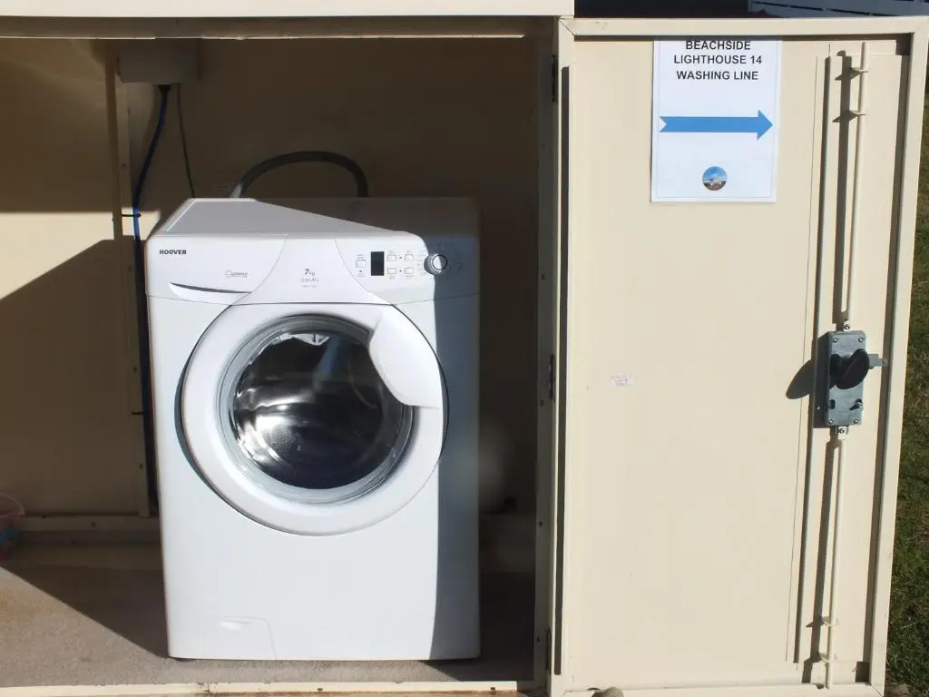 a washing machine in a box with a sign next to it at Beachside Lighthouse 14 in Lossiemouth