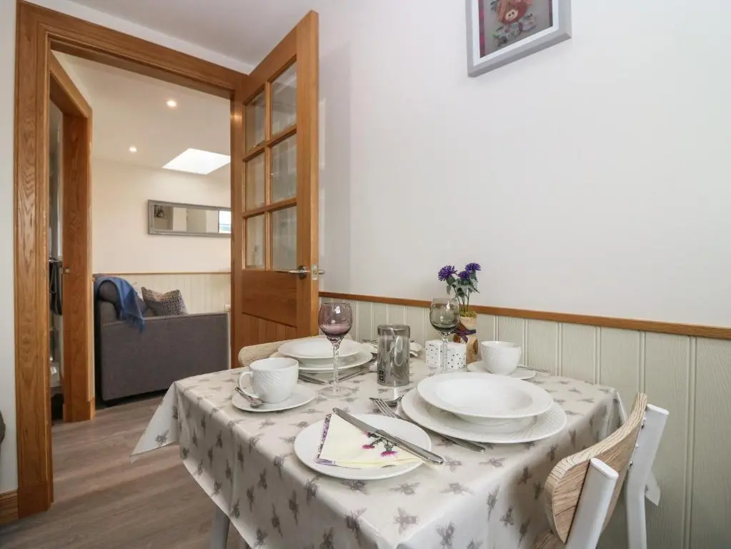 a dining room table with a white table cloth at Garden Studio in Insch
