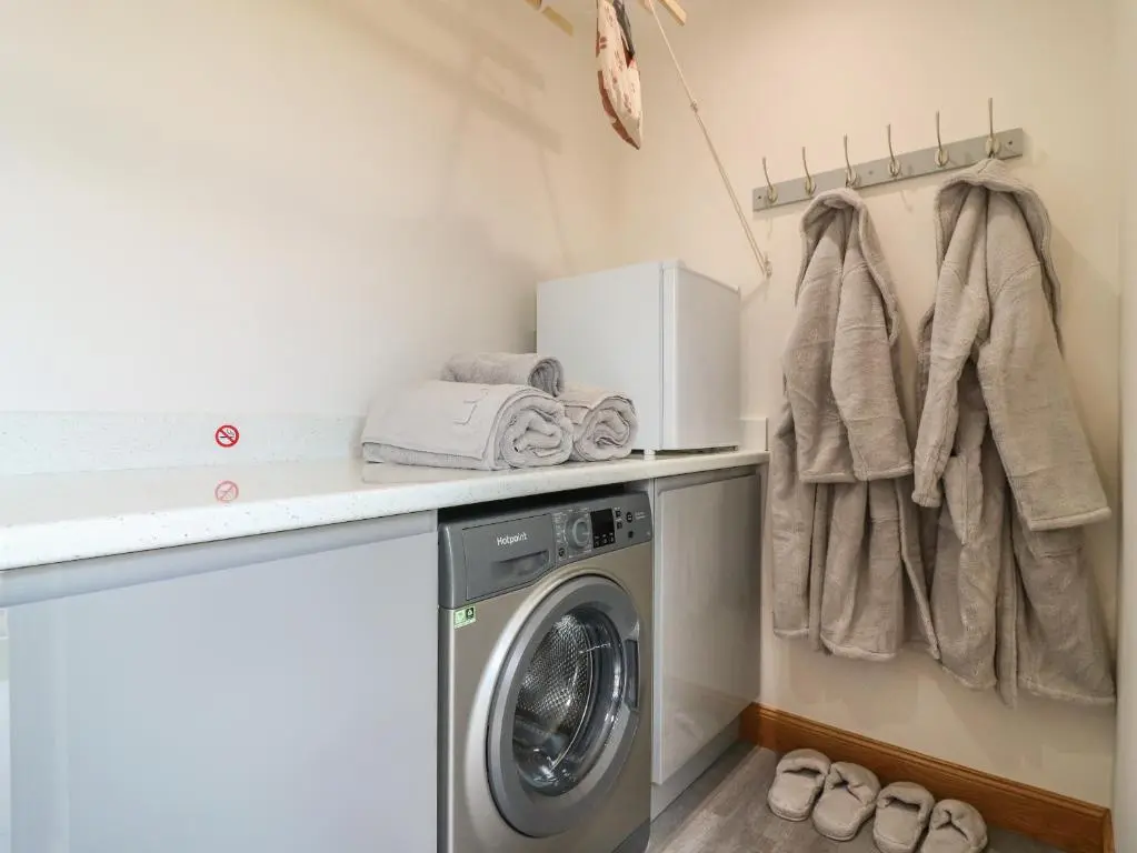 a laundry room with a washing machine and towels at Garden Studio in Insch
