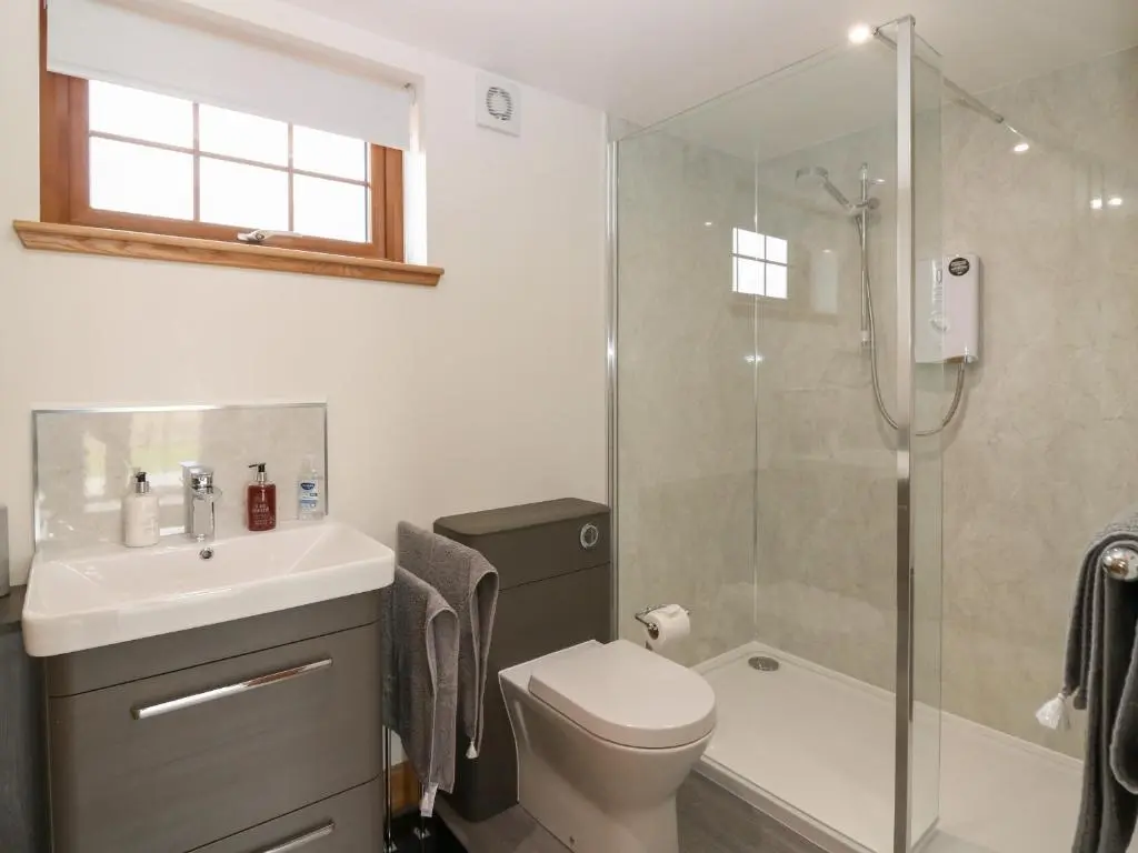 a bathroom with a shower and a toilet and a sink at Garden Studio in Insch