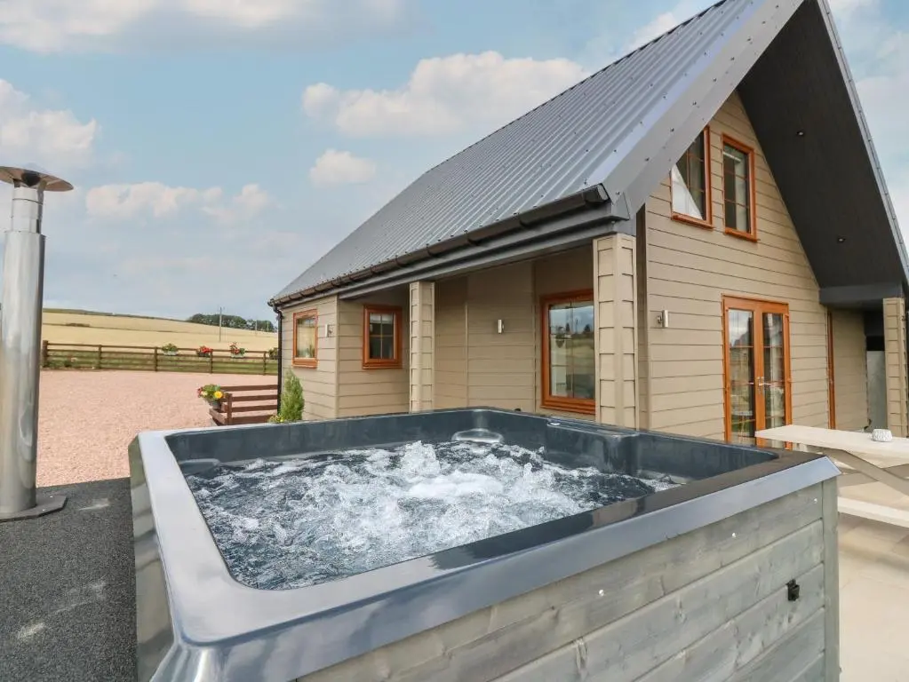 a hot tub in front of a house at Garden Studio in Insch